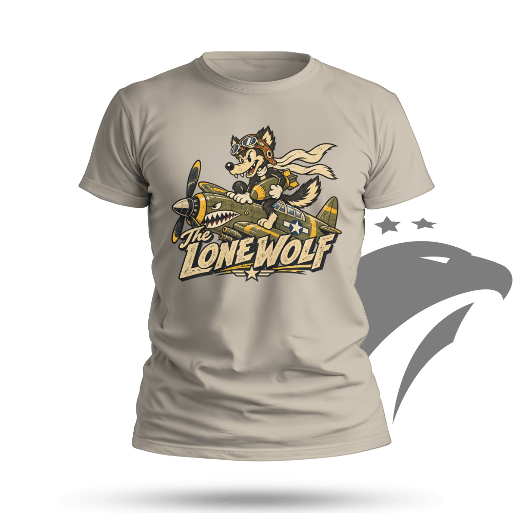 A light beige crewneck t-shirt featuring a graphic of a cartoon lone wolf in a pilot helmet flying a yellow and green fighter plane, with the text 'THE LONE WOLF' below. The t-shirt is displayed on a solid green background with a gray eagle silhouette and a black oval shadow underneath.